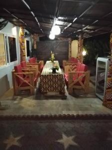 科托努Residence Ivoire Cotonou的一间带桌子和红色椅子的用餐室