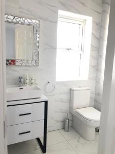 韦斯特波特Oak Tree Lodge的白色的浴室设有水槽和卫生间。