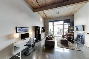 西雅图19th Avenue Lofts Unit 213的客厅配有书桌和沙发。