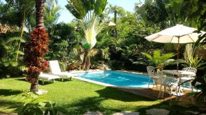 布希奥斯La Tropezina的庭院内的游泳池,配有桌子和遮阳伞