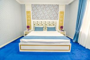 巴库Mensen Hotel Baku的卧室配有一张白色大床,铺有蓝色地板