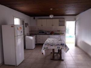圣达菲Casa-quinta Colastine Norte, Santa fe Argentina的厨房配有桌子和白色冰箱。