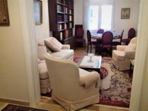 雅典George appartment的客厅配有白色的椅子和桌子