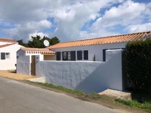 诺亚芒提亚Maison Bord de Mer au Vieil 3 étoiles的街道旁的白色房屋,设有围栏