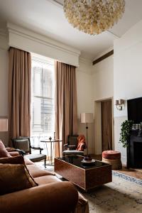 伦敦NoMad London的客厅配有沙发、椅子和吊灯