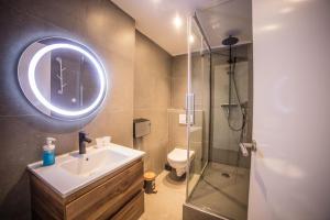 斯鲁伊斯Hotel Le Provencal的一间带水槽和玻璃淋浴的浴室