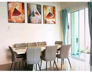 瓜埠GUESTHOUSE #1 SEMI Bungalow House的餐桌、椅子和墙上的绘画