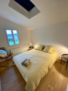 勒帕莱Maison spacieuse à deux pas de la plage …的卧室配有一张带两个枕头的大白色床