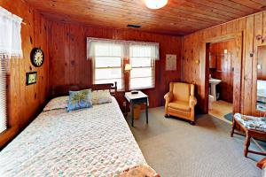默特尔比奇Vintage Bungalow的一间卧室,卧室内配有一张床和一把椅子