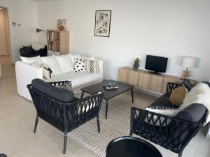 奥斯坦德Lichtrijk 2-slaapkamerappartement met zeezicht en gratis parking的客厅配有沙发、椅子和桌子
