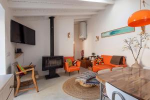 阿尔热祖尔Hillside 1 Aljezur old town的客厅设有壁炉和橙色椅子