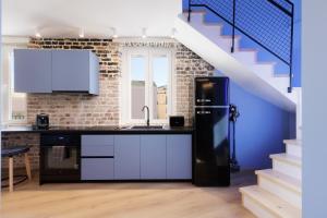 科孚镇Vailato Loft Suites的一间带黑色冰箱和楼梯的厨房