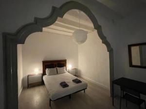 奥洛特Cal Mestre- Olot的一间卧室设有一张床和一个拱门