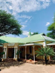 弗朗西斯敦Ngangane Lodge & Reserve的一座拥有绿色屋顶和棕榈树的房子