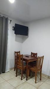 San RafaelHospedaje Rio Celeste Katira, Habitación privada的一张带椅子的木桌和墙上的电视