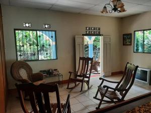 莫约加尔帕Ometepe House的客厅配有椅子和桌子,设有窗户