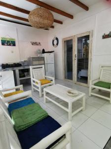 吉利特拉旺安Sahara Sands Guest House - Gili Trawangan的客厅配有椅子和桌子