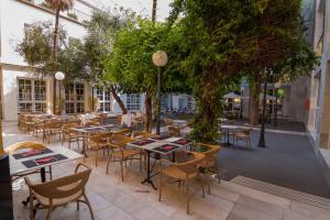 塞维利亚圣吉尔酒店的户外庭院配有桌椅和树木。