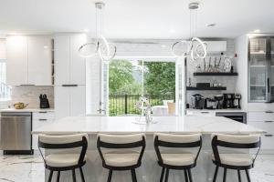 SheffordB&B Suite INN Abondance & SPA的白色的厨房配有大白色的桌子和椅子