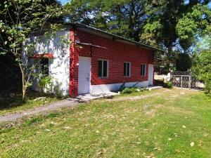 ShādipurThe Leisure Home Stay的红砖房子,有白色的门和院子