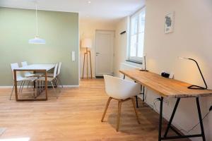 科隆Apartment - Neu, modern, gemütlich, eigener Parkplatz的客厅配有桌子和白色椅子