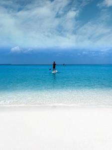 VashafaruBlue Coral Vashafaru Maldives的站在海洋冲浪板上的人