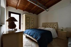 托雷拉皮罗villa Dimora Arnesano的一间卧室配有一张床和一张桌子上的台灯