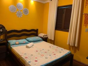 卢米亚Casa em Lumiar - Barulhinho do Rio的一间卧室配有一张黄色墙壁的床