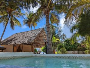 乌罗阿乌罗阿月光精品酒店的棕榈树和游泳池的度假村