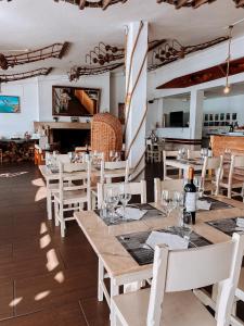 米尔芳提斯城Hotel HS Milfontes Beach - Duna Parque Group的一间设有白色桌子和白色椅子的餐厅和一间房间