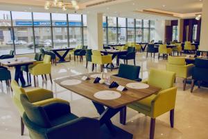 利雅德Hayat Al Riyadh Washam Hotel的用餐室设有桌椅和窗户。