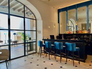 马略卡岛帕尔马Hotel Basilica的餐厅设有酒吧,配有蓝色椅子