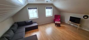 艾于兰Cheerful 4-bedroom home with fireplace, 1,5km from Flåm center的带沙发和红色椅子的客厅