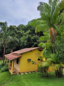 多明戈斯马丁斯Espaço inteiro: Casa de campo nas montanhas的旁边是棕榈树的黄色房子