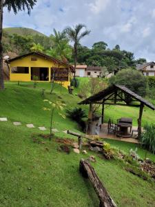 多明戈斯马丁斯Espaço inteiro: Casa de campo nas montanhas的院子里的黄色房子,带野餐桌