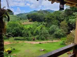 多明戈斯马丁斯Espaço inteiro: Casa de campo nas montanhas的从带绿地的房子的门廊上可欣赏到风景