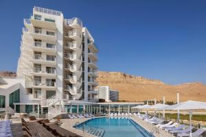 恩波其克Herbert Samuel Hod Dead Sea Hotel的一座酒店,在一座建筑旁边设有游泳池
