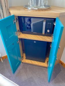 波特里An-Airidh Bed & Breakfast Portree的上面有微波炉的蓝色橱柜