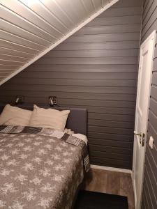 波多Feriehus ved Saltstraumen的一间卧室设有一张床和灰色的墙壁