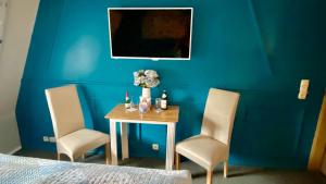伊尔梅瑙Froeschlein 2 - no Gitters & craftsman的一间卧室配有桌子和两把椅子,还有一面蓝色的墙壁
