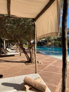 Douar Caïd Layadi曼希尔托图住宿加早餐旅馆的一条毛巾躺在泳池旁的床上