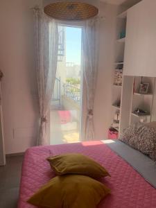 托雷拉皮罗Villa Medea的一间卧室配有一张带粉色毯子的床和窗户。