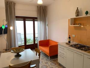 夏卡Appartamento Mare Blu的厨房配有橙色椅子和桌子