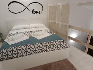卡塔尼亚mungiBEDdu Apartment的卧室配有一张挂有爱情标志的床