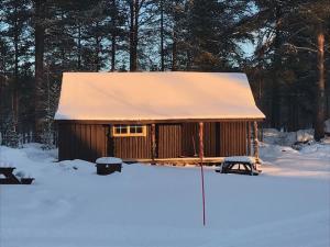 ElgaBåtstø Camping的雪中带雪盖屋顶的小屋
