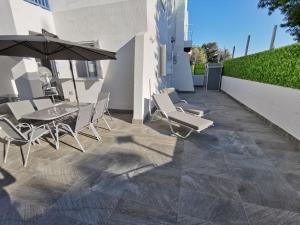 帕福斯Paphos Gardens Apartment的庭院配有桌椅和遮阳伞。