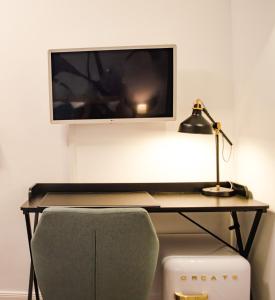 慕尼黑HOMELY STAY Studio 2的一张桌子,配有显示器、一盏灯和一把椅子
