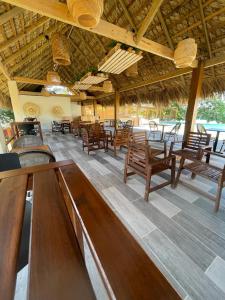 蓬塔露奇亚Hotel Sand Bay的一间设有木椅和桌子的餐厅以及屋顶
