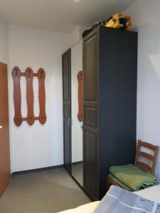 爱尔福特Ferienwohnung Döring的卧室配有黑色橱柜,墙上挂有吉他