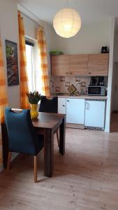吕贝克1-Zimmer-Apartment-2-Hochparterre的厨房配有木桌、椅子和桌子,厨房